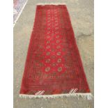A vintage red ground rug approx 102cm w 290cm L