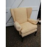 A cream wing back chair