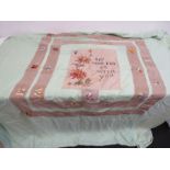 An embroided bed throw with quote and flowers