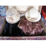 A vintage suitcase with hats, fur coats and curtains etc