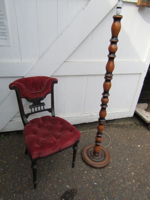 Upholstered mahogany chair and turned wooden floor lamp