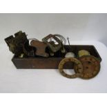 A compart metal box containing many mechanical clock parts including spring clock faces, two clock