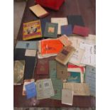 a red box of ephemera to include vintage singer sewing booklets, leaflets, maps, identity cards