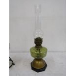 A yellow glass brass based oil lamp