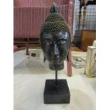 A resin buddha head on plinth