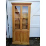 A pine bookcase with cupboard and glazed doors