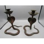 A pair of brass cobra candle stick holders