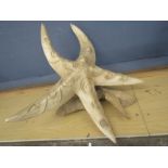 A star fish made from banana leaf? raffia? mounted on a piece of driftwood approx 30cmH and 55cm