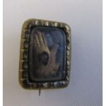 A Victorian brooch possibly pinchbeck with a gloved hand with a red heart