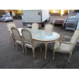 A French style dining table with 6 chairs The table has wicker type top with glass overlay, 4