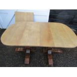A double pedestal table with extending leaf, top has been stripped back