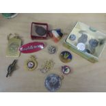 A collection of vintage badges and military buttons