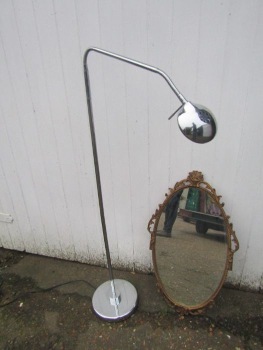 Ornate gilt framed wall mirror and chrome floor lamp