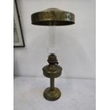 A brass base oil lamp with brass shade to the top