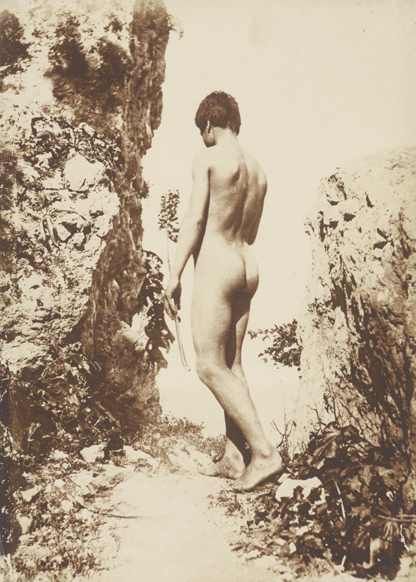Gloeden, Wilhelm von: Male nude on cliffs