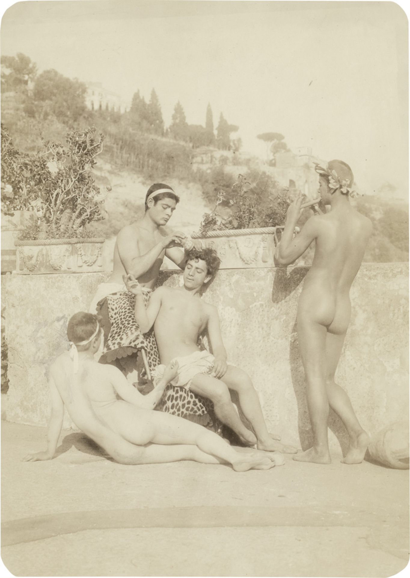 Gloeden, Wilhelm von: Group of nude youths in front of Arcadian landscape