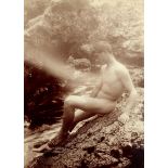 Gloeden, Wilhelm von: Male nude on rocks by the sea