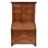 An 18th Century oak bureau cabinet:, the upper part with a moulded dentil cornice,