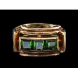 A 1940s green tourmaline ring,: set with three square cut green tourmaline, between scrolled sides,