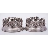 A pair of late Victorian / Edwardian plated wine coasters: with grape and vine leaf galleried sides,