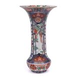 A Japanese Imari sleeve vase: painted with underglaze blue bordered panels of peony,