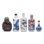 A group of four Chinese porcelain snuff bottles and stoppers and an agate snuff bottle: one painted