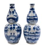 A pair of Chinese blue and white double gourd vases: each painted with figures in continuous lake