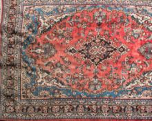 A Turkish carpet:with central aubergine medallion to the rose field,