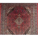 An Indo Persian carpet:, the rose field with a central ivory shaped lozenge pole medallion,