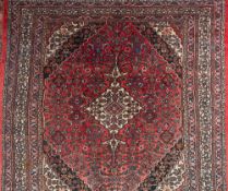 An Indo Persian carpet:, the rose field with a central ivory shaped lozenge pole medallion,