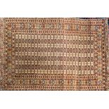An Iranian Rug:, of Turkoman design, the beige field with four rows of quartered medallions,