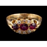 An 18 carat gold ruby and diamond ring,: the three oval cut rubies with old diamonds to the side,