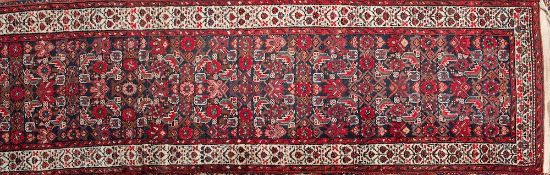 A Hamadan runner:, the indigo field with an all over geometric leaf and flowerhead design,