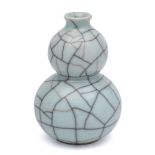 WITHDRAWN A Guan type vase: of double gourd form under crazed celadon glaze, 13cm high.