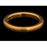 A 22 carat gold ring,: the plain polished band, stamped 22 with full Birmingham hallmarks,