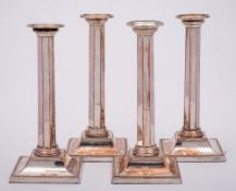 A set of four Sheffield plate candlesticks: with plain sconces and beaded nozzles,
