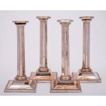 A set of four Sheffield plate candlesticks: with plain sconces and beaded nozzles,