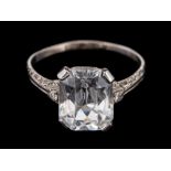 A white spinel and diamond ring,: the central rectangular cut white spinel in a four claw setting,
