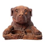 A Black Forest carved linden wood smoker's companion: in the form of a dog's head and paws resting
