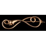 A gold coloured snake brooch,: designed as a twisting abstract snake, 5.5cm wide.