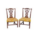 A pair of George III carved mahogany dining chairs in the Chippendale taste: the backs with