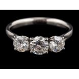 A platinum diamond three stone ring,: the central brilliant cut diamond estimated to weigh 0.