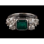 An emerald and diamond ring: the square cut emerald, in a collet setting,