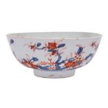 A Chinese Imari bowl: painted with knarled branches of blossom and a large butterfly,