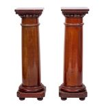 A pair of mahogany cylindrical jardiniere stands:, with square tops and canted square bases,