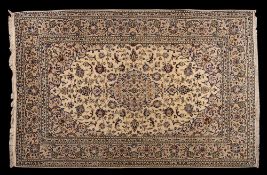 A Kashan carpet:, the ivory cartouche field with a central cartouche pole medallion,