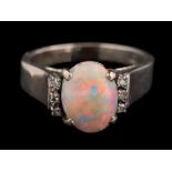 An opal and diamond ring,: the oval cabochon opal claw set between eight cut diamond set shoulders,