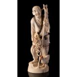 A Japanese ivory okimono of a peasant farmer: holding a basket of grapes,