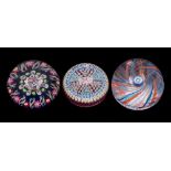 Three Scottish paperweights: comprising a close pack millefiori example with multi-coloured canes
