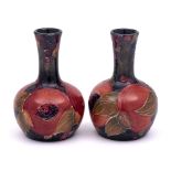 A pair of William Moorcroft miniature bottle vases: each tube-lined and decorated in the